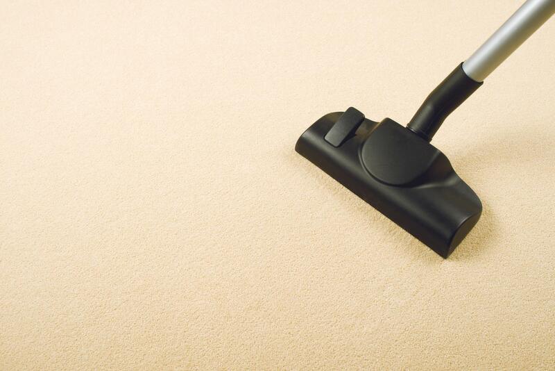 someone vacuuming the beige carpet