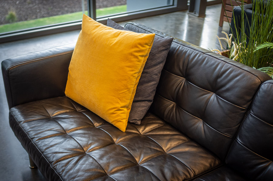 black leathered sofa with pillows