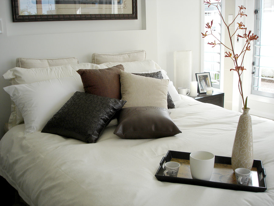 clean and simple bed with mugs and vase on the side
